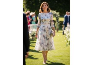 Elegancka kobieta w pastelowej sukience na weselu w ogrodzie, z naturalnym makijażem i minimalistyczną biżuterią.