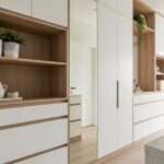 Nowoczesny przedpokój z wbudowanymi szafkami, lustrem i minimalistyczną dekoracją w jasnym wnętrzu